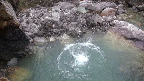 Slow motion: stone falls into the water making a huge splash, and reverse motion Stockbeeldmateriaal 76770310