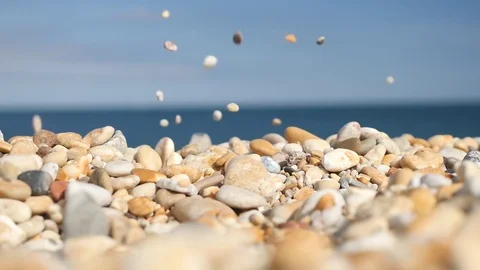 Slow motion stones falling on beach Stock Footage 77436171