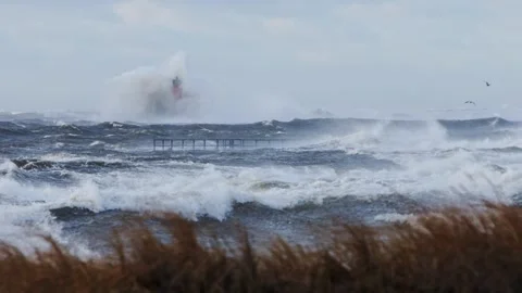 Slow Motion Storm Wave Crashes on Orange Lighthouse, Baltic Autumn at Mangaļsala Stock Footage 310719928