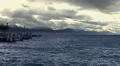 Slow motion of stormy waterscape, empty lakeside, heavy clouds above mountains HD Footage