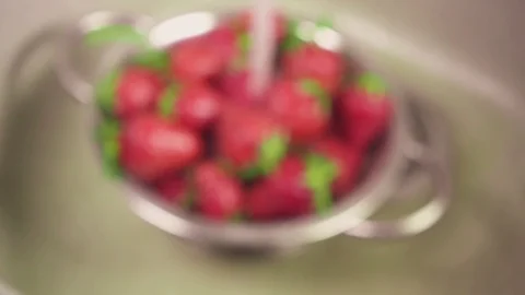 Slow motion strawberries in a colander under the water in the sink Stock Footage 90256843