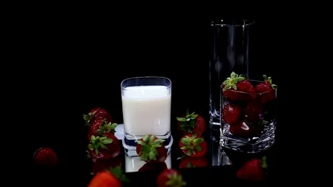Slow motion of a strawberry falling inside the milk - black background Video stock 109042930