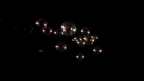 Slow motion stream of bubbles from the left against black Stock Footage 77134523