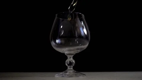 Slow motion of a stream of cognac pouring into a glass Stock Footage 93294547