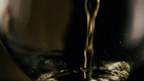 Slow motion. A stream of cognac pours into the glass Stock-Footage 75446847