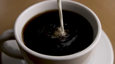 Slow Motion of a Stream of Cream Pouring Into a Mug of Coffee Stock Footage 270392453