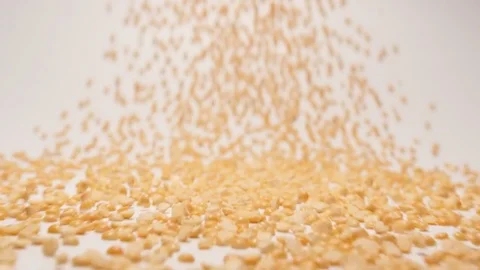 SLOW MOTION: Stream of dried yellow peas moving to a camera Vídeo Stock 70572796