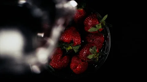 Slow motion. A stream of water pours strawberries in a bowl Stock Footage 75479391