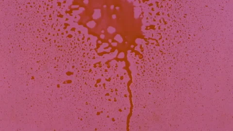 Slow motion. Streams of red paint fall into the center of a pink background and 库存影片 168570290