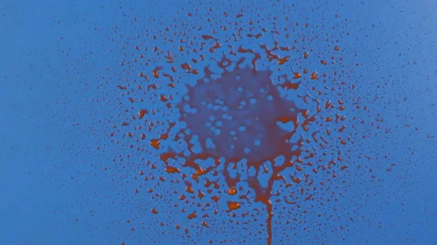 Slow motion. Streams of red paint fall into the center of a blue background and 库存影片 168570850