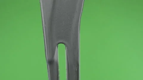 Slow motion. Streams of silver paint on a green background. Close-up of silver Stock Footage 157084510