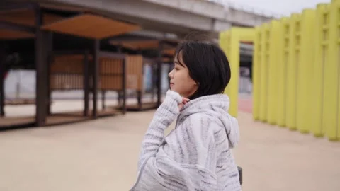 Slow Motion Stroll: A Young Woman's Calm Walk Amidst Urban Hustle Video stock 276513316