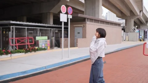 Slow Motion Stroll: A Young Woman's Calm Walk Amidst Urban Hustle Vidéo 276513428