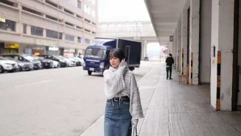 Slow Motion Stroll: A Young Woman's Calm Walk Amidst Urban Hustle Stock Footage 276513763