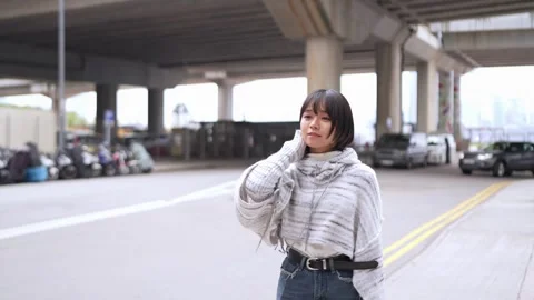 Slow Motion Stroll: A Young Woman's Calm Walk Amidst Urban Hustle Stock Footage 276516971