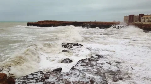 Slow motion of a strong and powerful sea wave crashing against a rocky shore Stock Footage 133809811