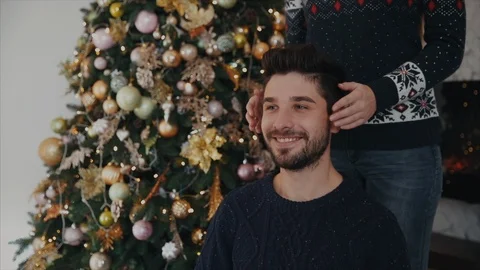 Slow motion. Studio shot. A man is sitting on the chair, a woman reaches him and Stock-Footage 104148025