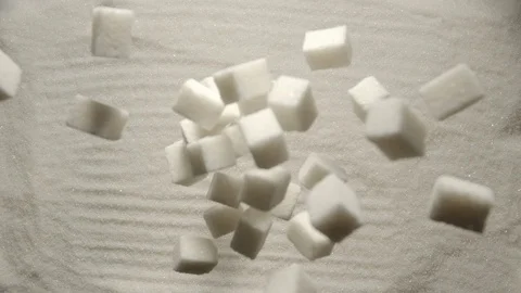 SLOW MOTION: Sugar cubes falling onto a heap of white sugar Stock Footage