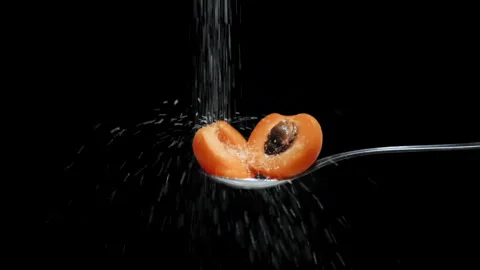 Slow motion of sugar poured over open peach apricot Stock Footage 131406340