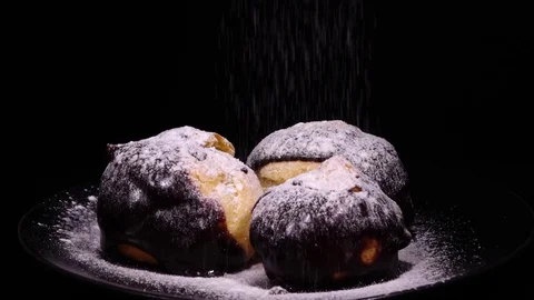 Slow motion of sugar powdering of three eclairs, poured with dark chocolate Stock Footage 74883506