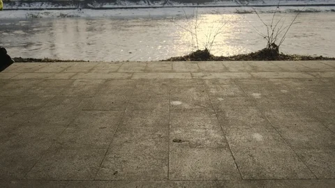 Slow motion: Sun casts shadows of people walking on the waterfront. 4k. Видео 103474358