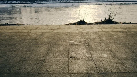 Slow motion: Sun casts shadows of people walking on the waterfront. 4k. Видео 103474698