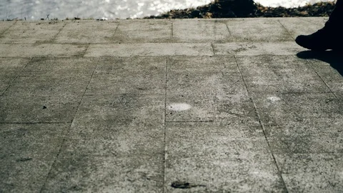 Slow motion: Sun casts shadows of people walking on the waterfront. 4k. Vídeos de archivo 103475400