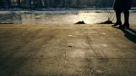 Slow motion: Sun casts shadows of people walking on the waterfront. 4k. 스톡 동영상 103475461