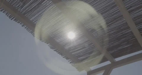 Slow Motion Sun Flare Through Straw Roof – Ungraded 4K S-Log3 Stock Footage 320104867