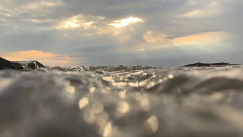 SLOW MOTION. Sun rays emerging through clouds in the middle of the rough exotic  Video stock 117273573