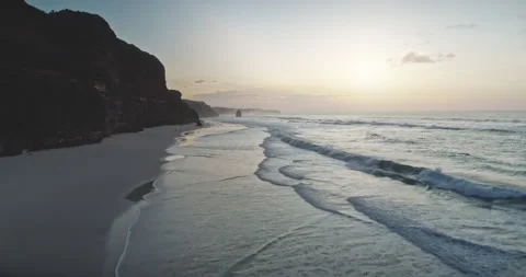 Slow motion sunrise at wavy ocean cliff coast aerial view. Sun rise at dark rock Stock Footage 139943313