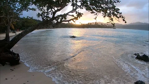 Slow motion at sunset on a Caribbean beach with sea waves, palm trees and san Vidéo 127274909