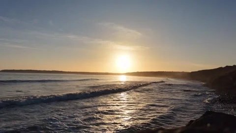 Slow Motion Sunset Over Ocean Waves Near Coastline in 4K Video stock 332944162