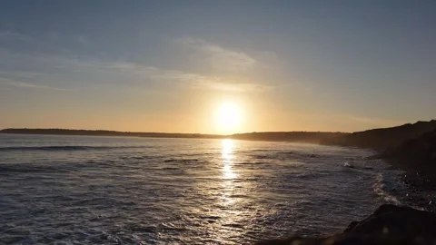 Slow Motion Sunset Over Ocean Waves Near Coastline in 4K Stock Footage 332944164