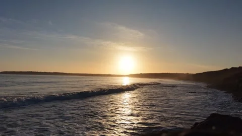 Slow Motion Sunset Over Ocean Waves Near Coastline in 4K Vídeo Stock 332944177
