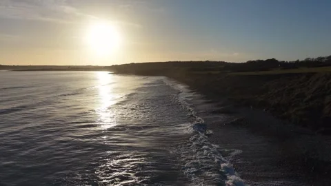 Slow Motion Sunset Over Ocean Waves Near Coastline in 4K Video stock 332944577