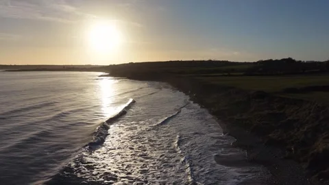 Slow Motion Sunset Over Ocean Waves Near Coastline in 4K Stock Footage 332944616