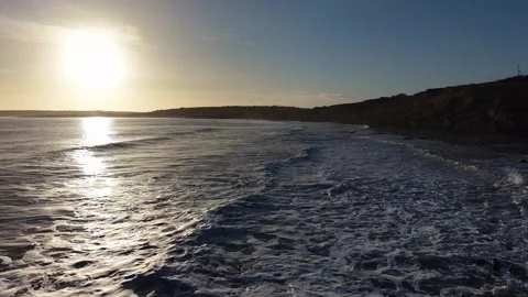 Slow Motion Sunset Over Ocean Waves Near Coastline in 4K Vidéo 332944648