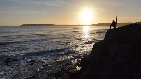 Slow Motion Sunset Over Sea Beside Dark Rocky Coast in 4K Stock Footage 332944363