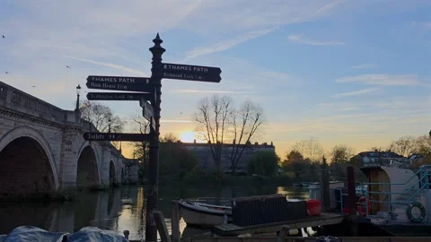 Slow Motion Sunset by Richmond Bridge and Thames Path Signpost Stock Footage 323428321