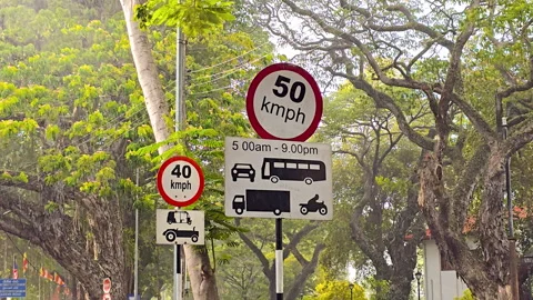Slow motion sunshower rain falling on city street with speed limit signs. Stock Footage 339967642