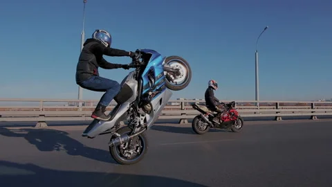 Slow motion. Super skilled crazy motorcyclist riding on the rear wheel of his Stock Footage 105012214