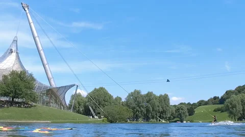 Slow motion of a surfer being pulled by a rope on the lake in Olympia park Stock Footage 135280573