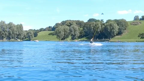 Slow motion of surfer having fun wakeboarding in Olympia park, Munich Stock Footage 106597367