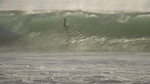 Slow motion of surfer paddling through breaking wave 4K Stockbeeldmateriaal 166757965
