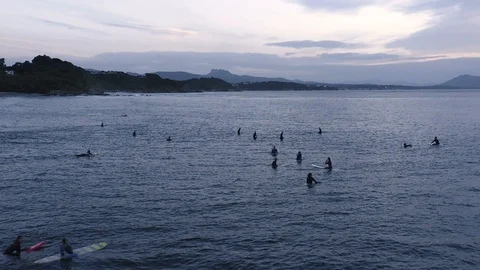 Slow motion surfers at dusk calmly wait for giant wave 2 Stock Footage 112700219
