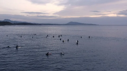 Slow motion surfers at dusk calmly waiting for next wave 2 Stock Footage 112700469