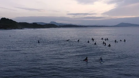 Slow motion surfers at dusk calmly waiting for next wave 3 Stock Footage 112700709