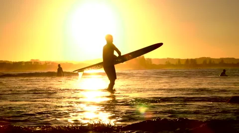 SLOW MOTION: Surfers spending summer vacation on surfing beach at golden sunset Stock Footage 64739941