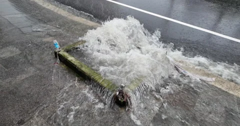 Slow-motion surge from storm drain in rainstorm. Stock Footage 340772989